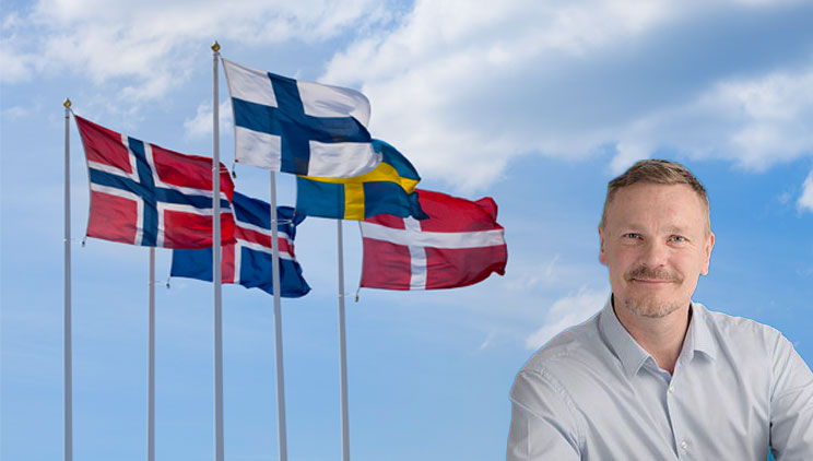 Nordic Regions flags on a blue sky and Peter Munch-Madsen Senior Advisor Nordic Innovation.